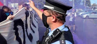 Polizist droht Demonstranten mit Waffe